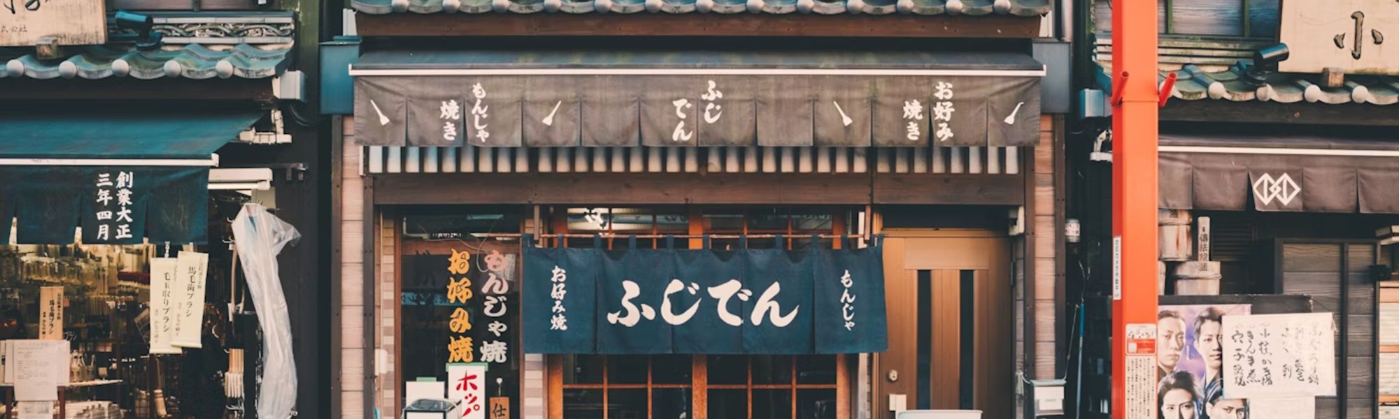 Ingresso di un ristorante tradizionale con tende noren e architettura in legno; un esempio degli scorci autentici scoperti durante i tour gastronomici on-ground di Hidden Japan.